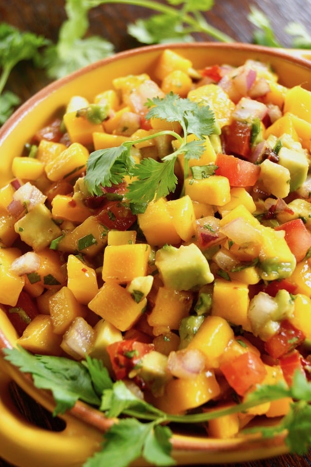 Mango Avocado Chipotle Salsa in a yellow bowl with fresh cilantro