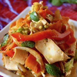 Mint tofu stirfry on a small white, square plate with red pepper strips