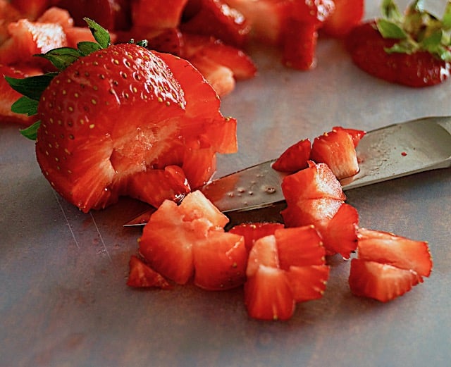 Strawberry being cut into small dice for Strawberry Avocado Salsa