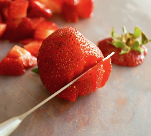 Strawberry being sliced for Strawberry Avocado Salsa