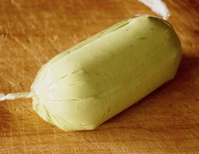A roll of firm Avocado Butter in plastic wrap.