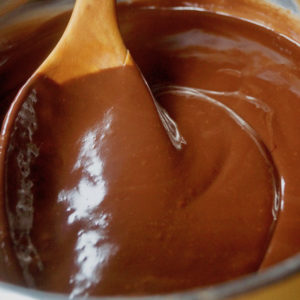 Close up of Ganache in stainless steel bowl with wooden spoon