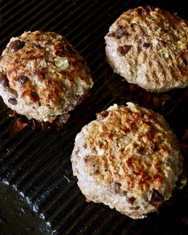 Three Grilled Mediterranean Burgers on the grill.