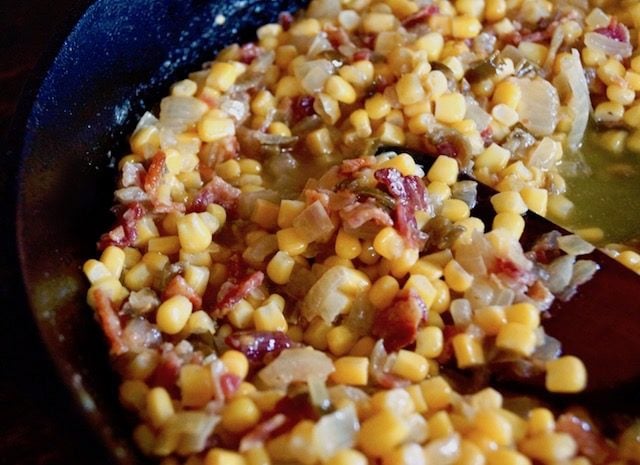 corn and bacon mixed in a cast iron skillet