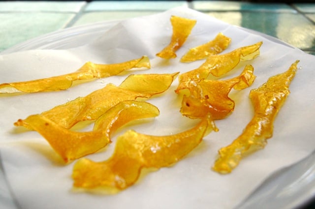 Candied Citrus Peels on a white towel on a light green tile countertop.
