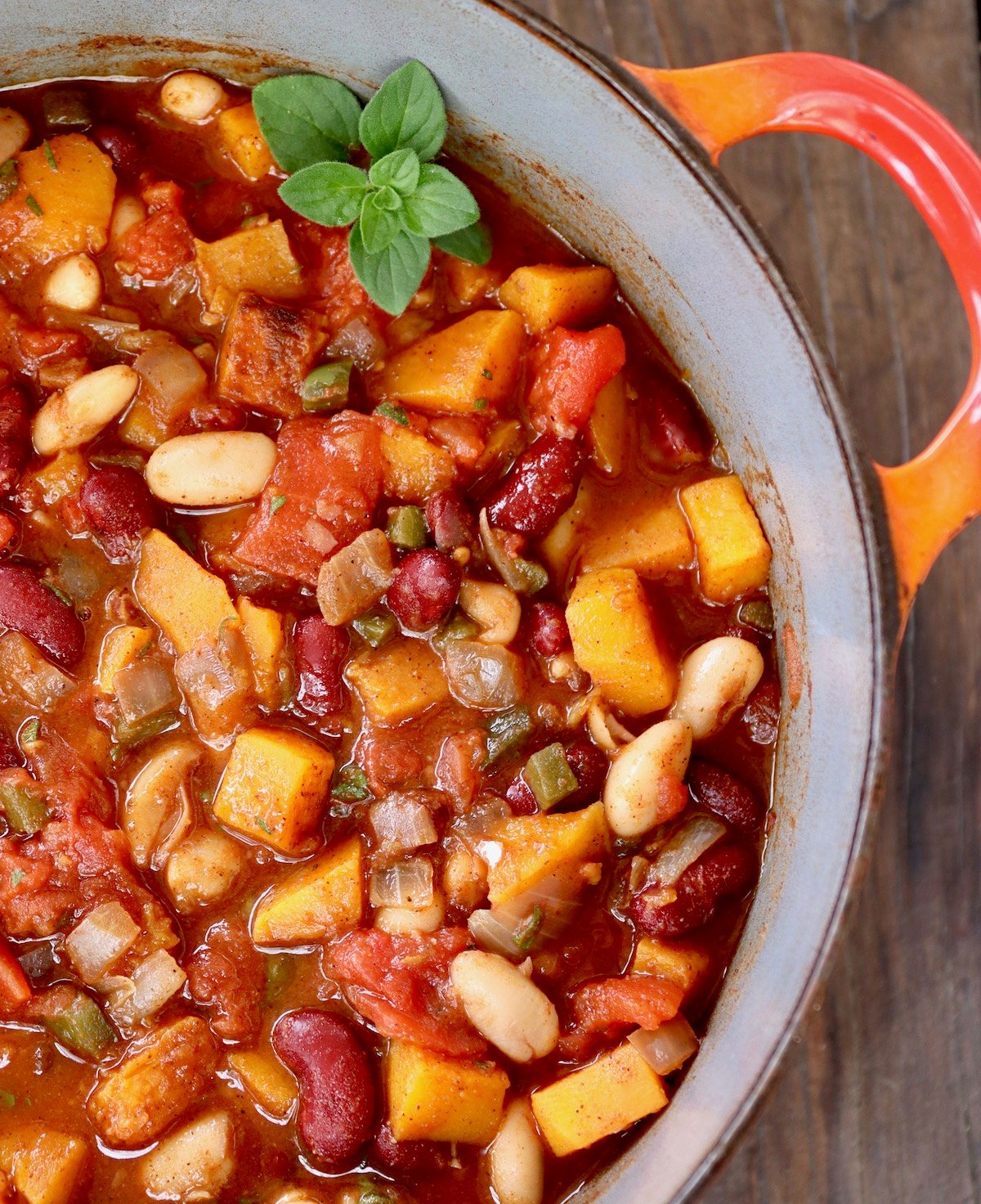 red-handled Dutch oven filled with squash chili