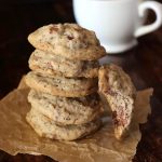 5 coffee chocolate chip coookies in a stack with one leaning on it with a bite taken out of it