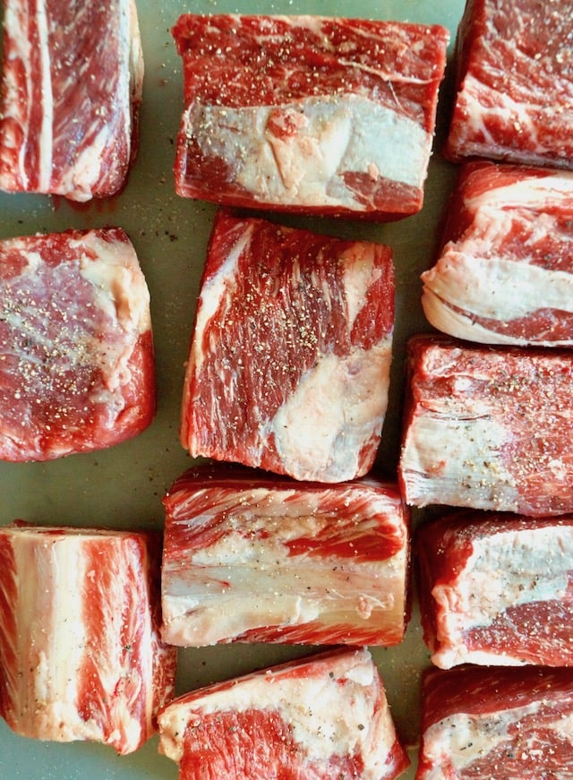 Several raw short ribs with satl and pepper.