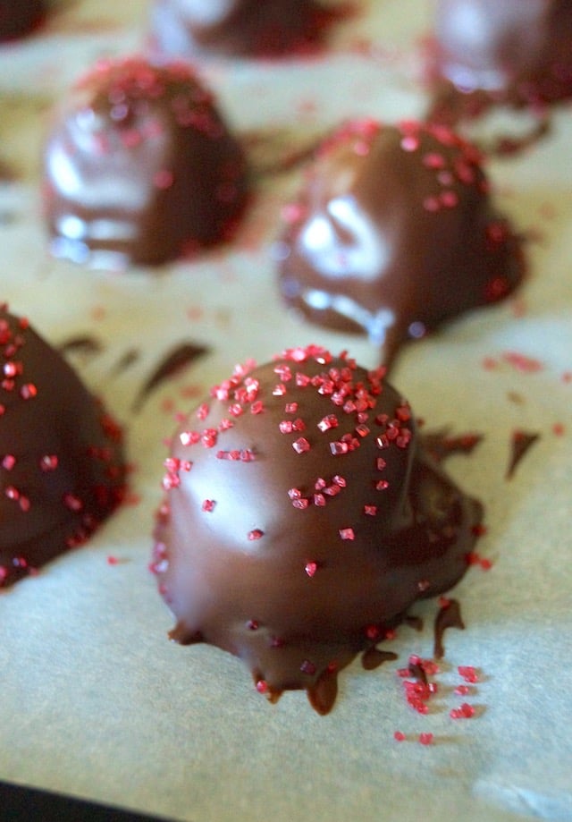 Slightly wet Spicy Mayan Chocolate Truffles with red sugar sprinkles.