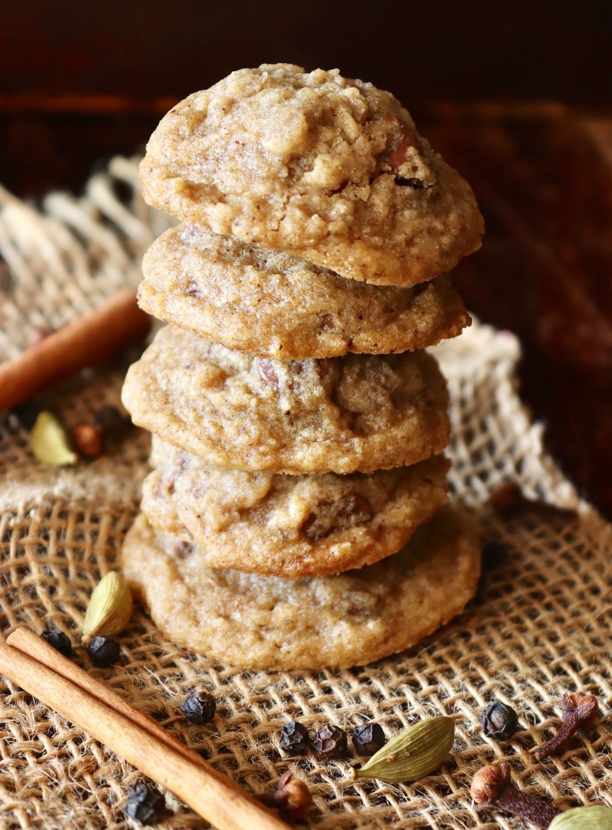 stack of 5 Chai Cookies on beige mesh cloth with connamon sticks.