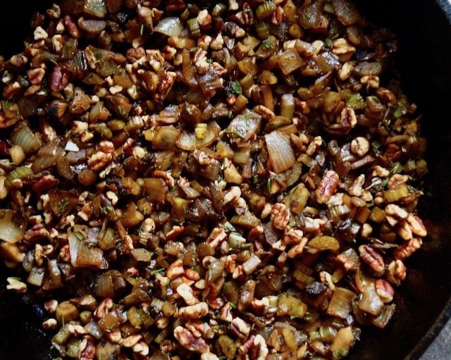 pecans, onions, herbs and celery in cast iron skillet for stuffing