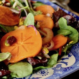 close up of Persimmon salad on blue and white china platter