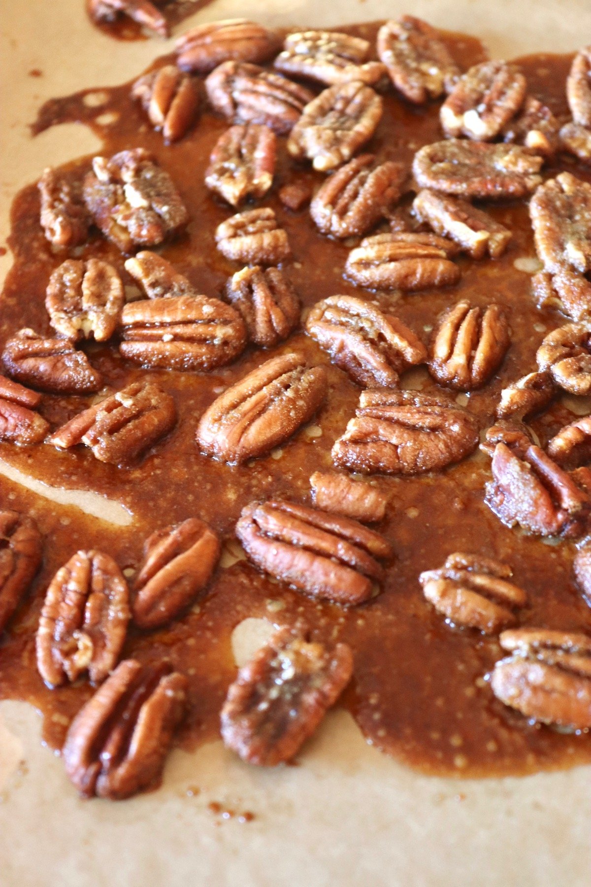 caramelized pecans with spice mix aspread out on baking sheet