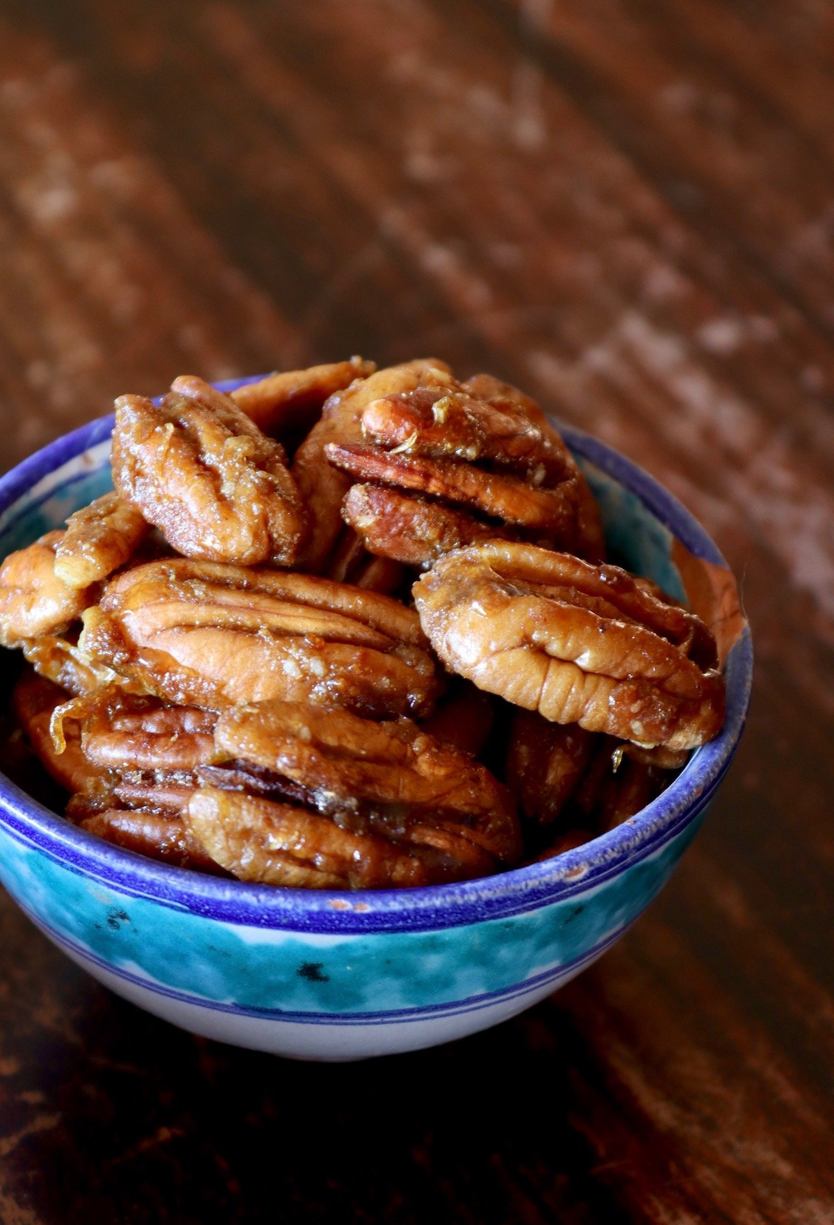 tiny blue bowl filled with caramelized pecans