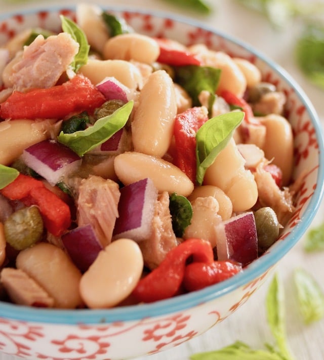 Close up of Cannelllini Bean Tuan Salad i a white bowl with blue trim and red flowers on it.