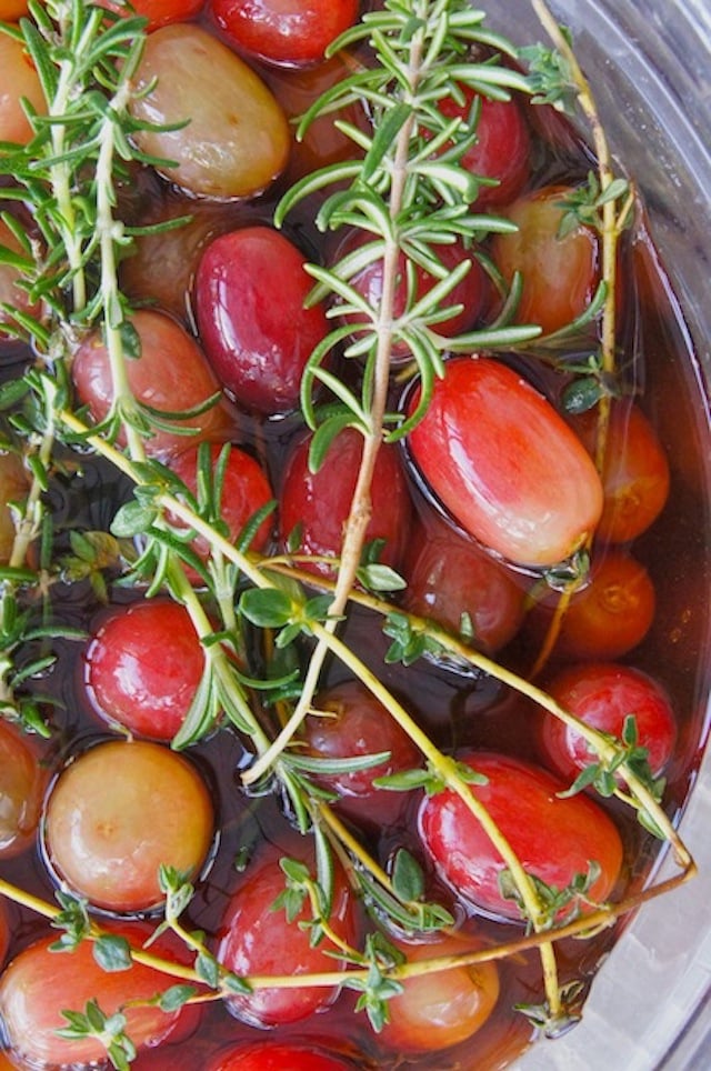 Wine Marinated Grapes in glass bowl with fresh herbs on top