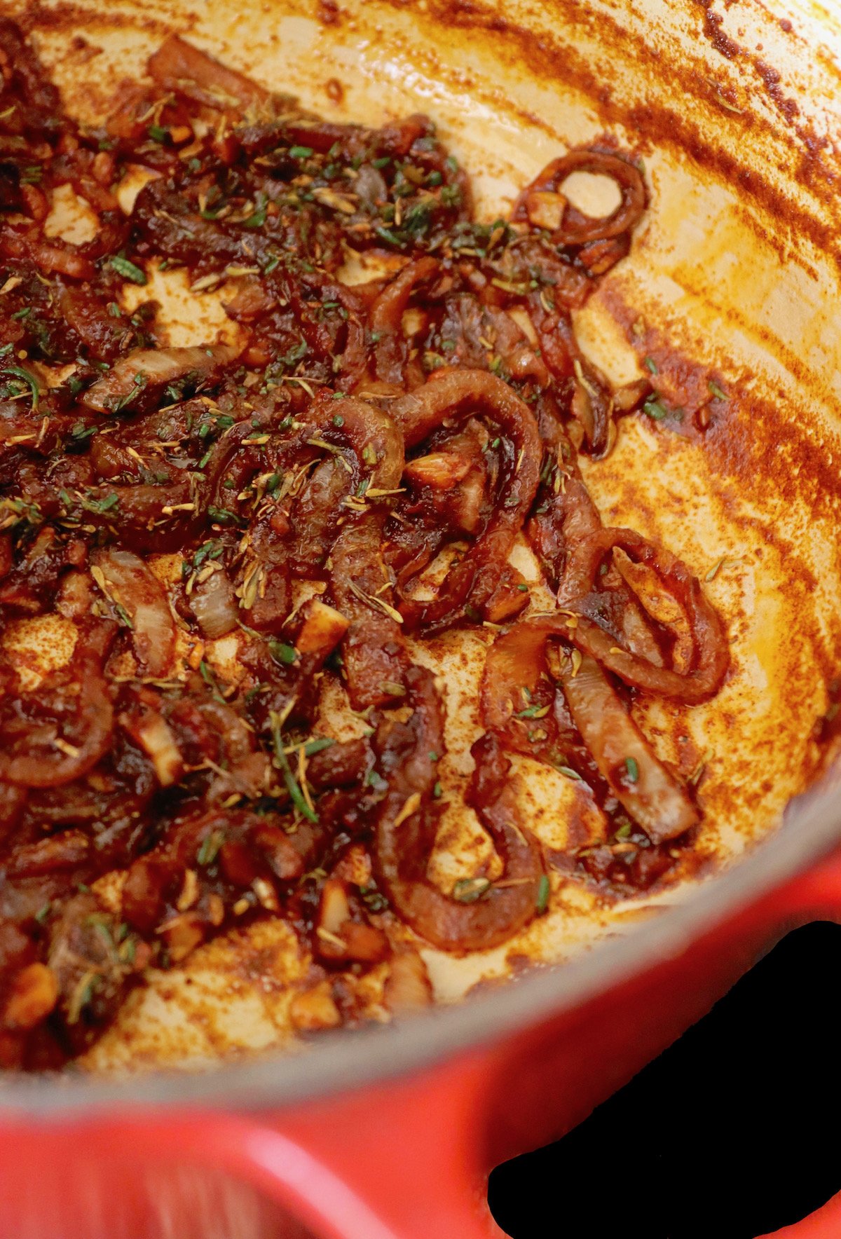 Caramelized Onions lining the bottom of a Dutch oven.