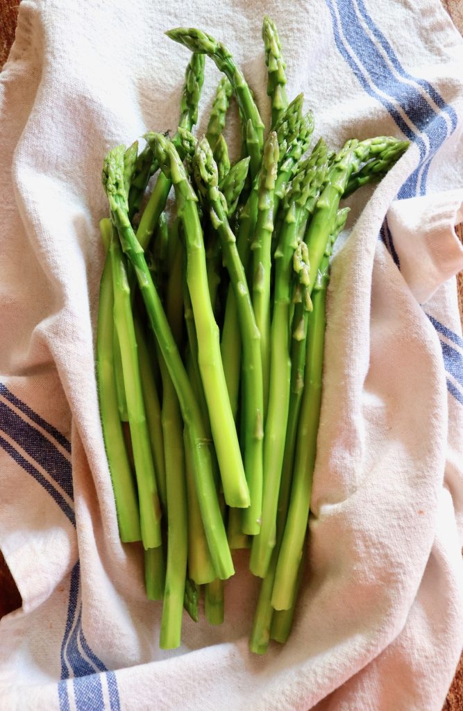 bright green, steamed asparagus on white towel