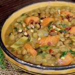 gold and black ceramic bowl with vegan lentil stew with carrots and coconut milk