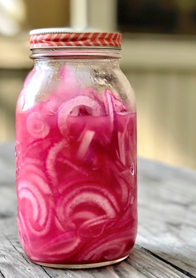 Pickled red onions with lime in a tall jar