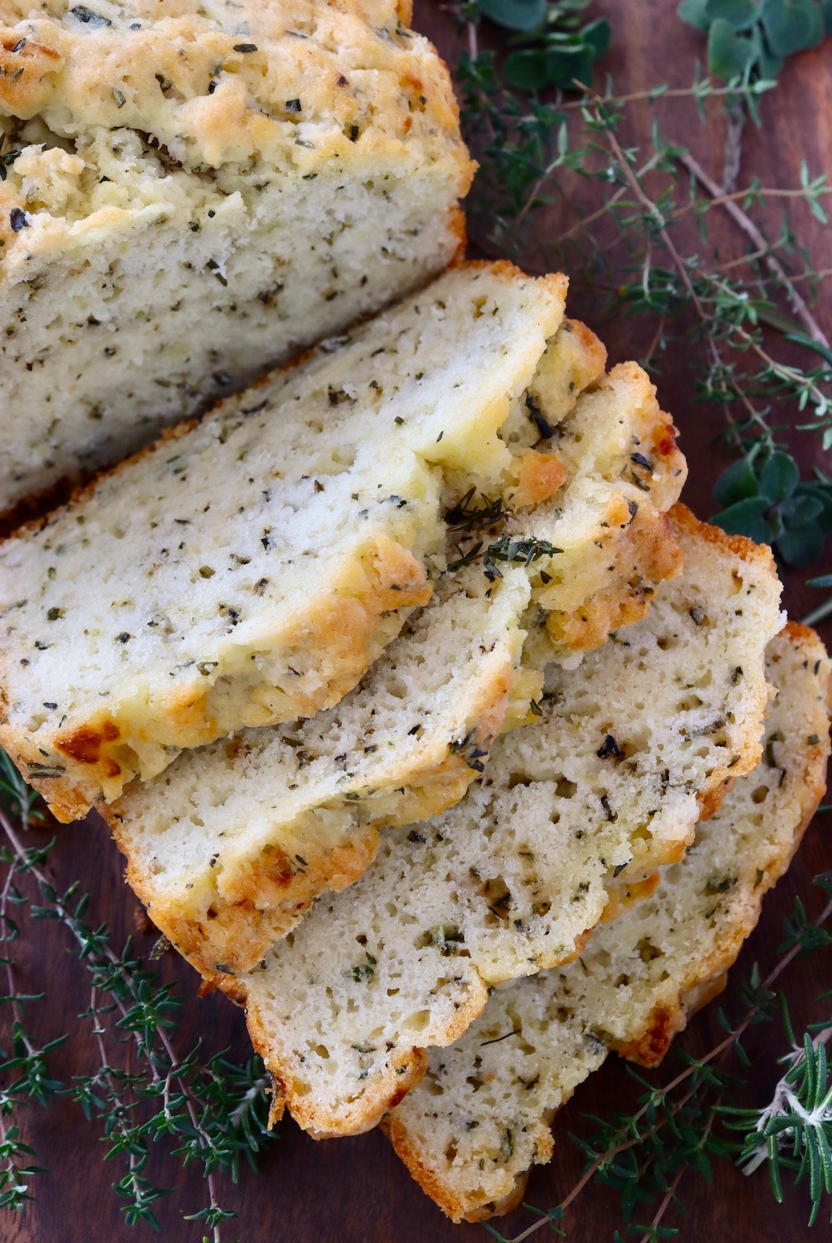 top view, close up of herb bread sliced on cutting board