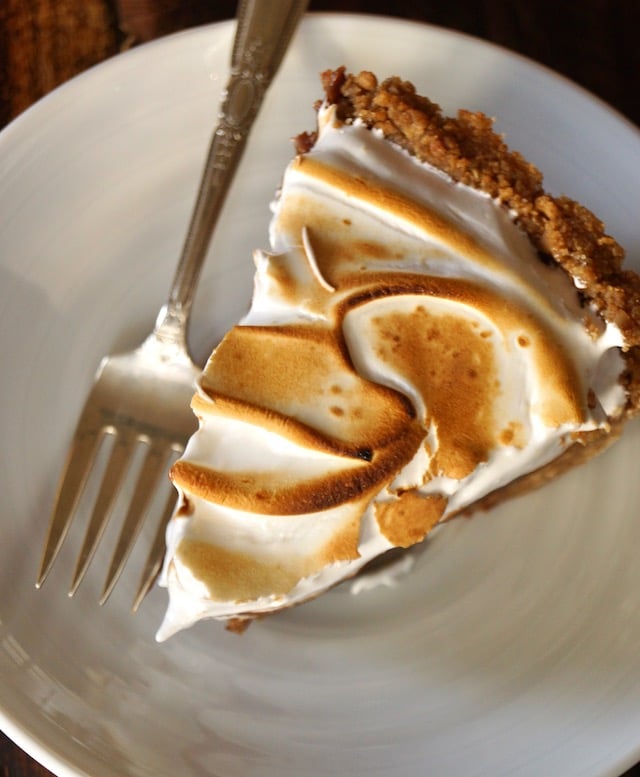 Top view of a slice of Peanut Butter Chocolate Meringue Pie on white plate with fork