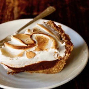 One slice of Peanut Butter Chocolate Meringue Pie on a white plate with fork