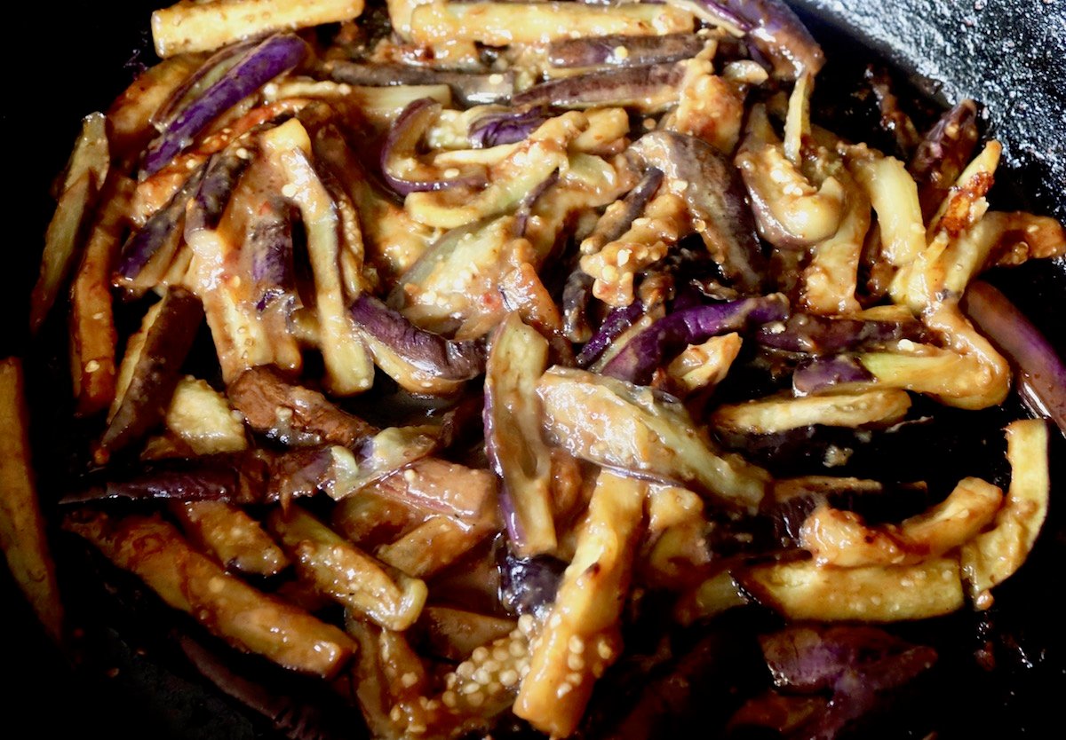 Cooked Miso eggplant in a large saute pan on the stove.
