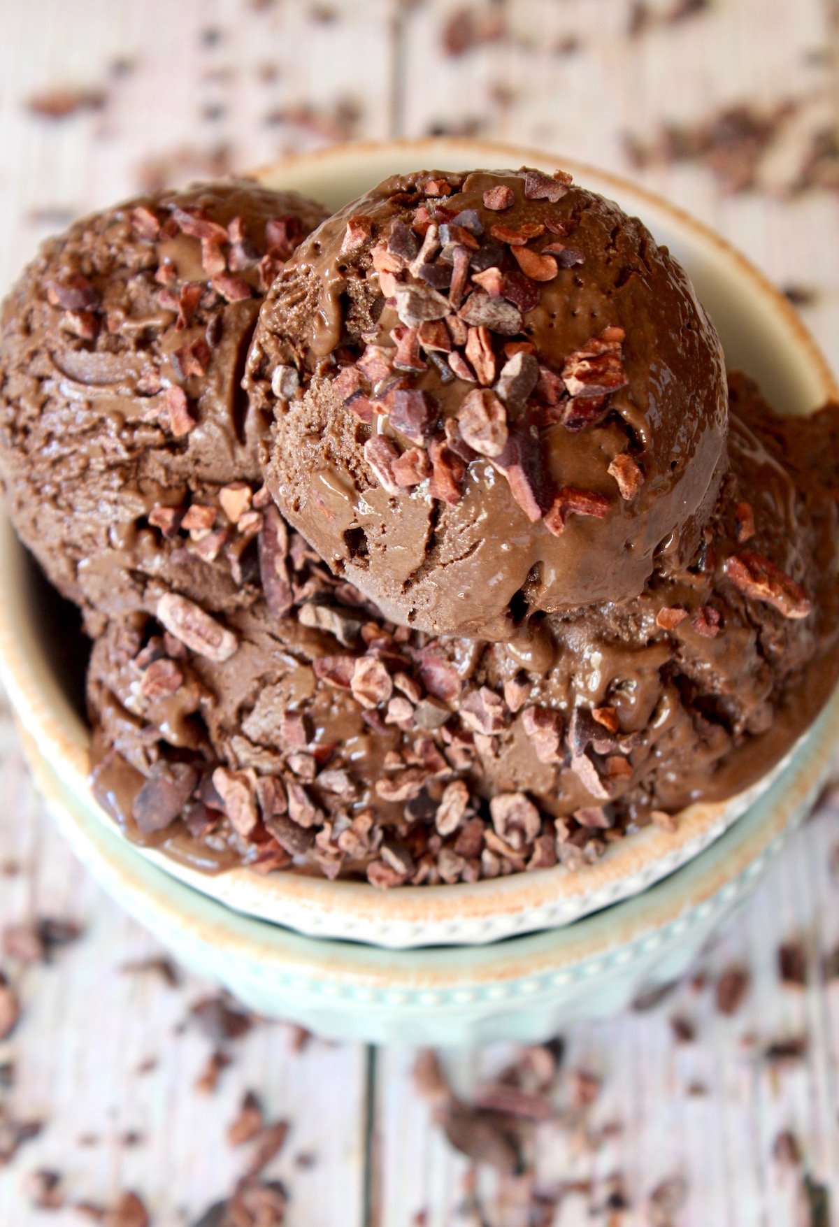 top view of a few chocolate gelato scoops with cacao nibs on top