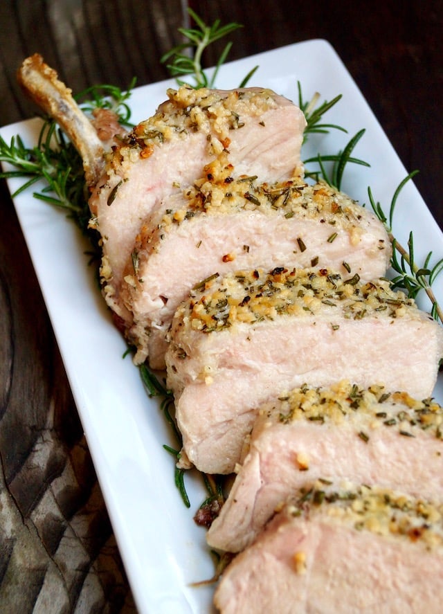 sliced garlic rosemary pork chop on white plate