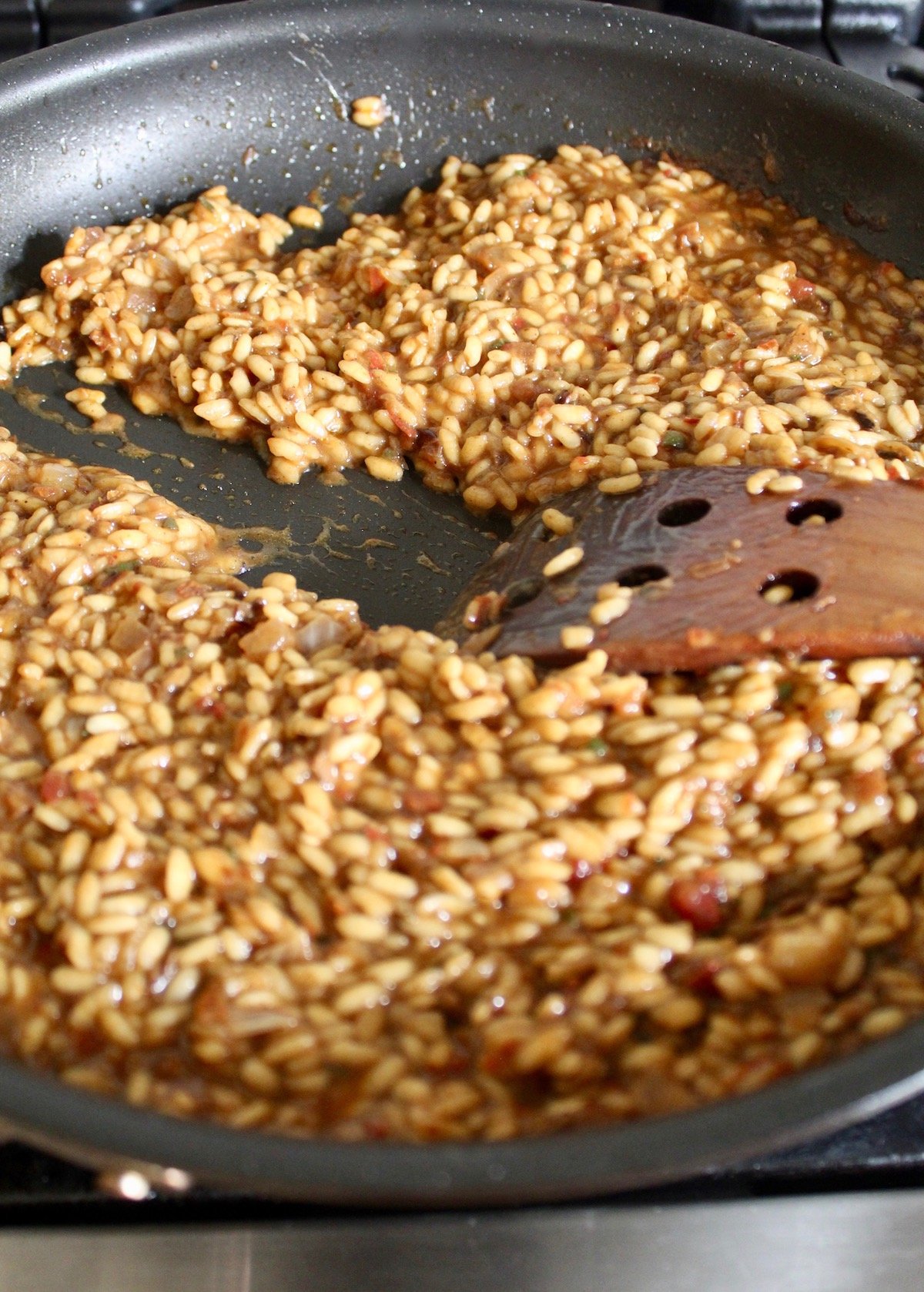 Brown butter pumpkin risotto in pan with wooden spatula stirring