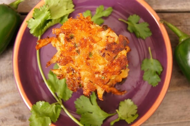 Top view of Mexican Cheesy Potato Pancakes on a purple plate with fresh cilantro