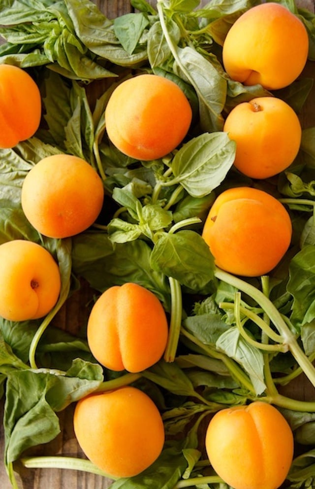 fresh basil and apricots on cutting board for Apricot-Basil Preserves Recipe