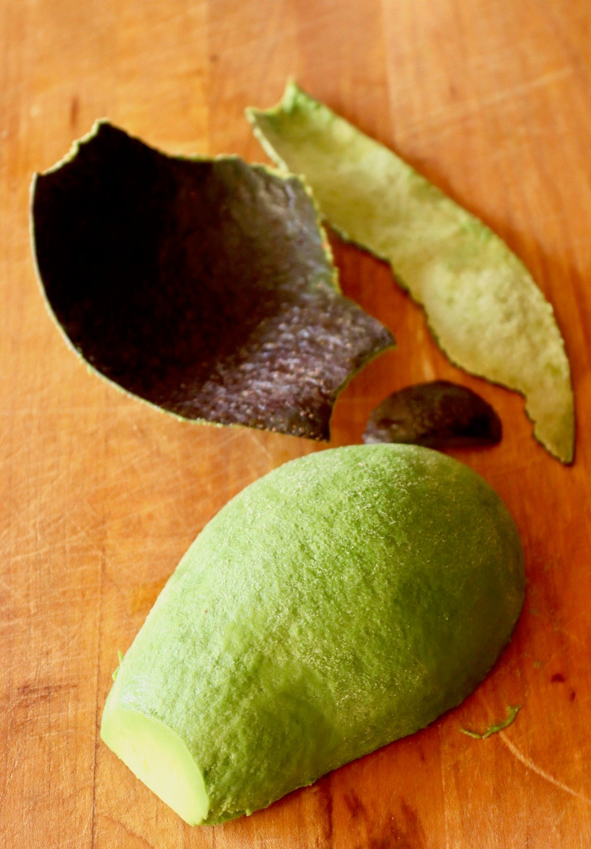 Avocado half, round side up, with skin peeled off.