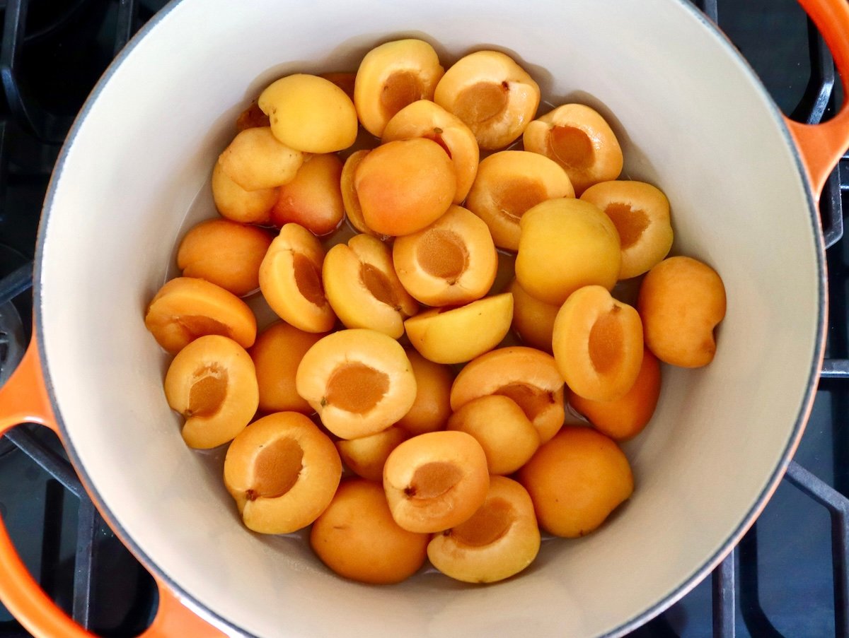 Dutch oven full of fresh apricots halves, pits removed.