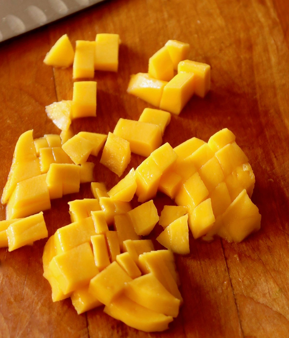 Diced mango on a cutting board.