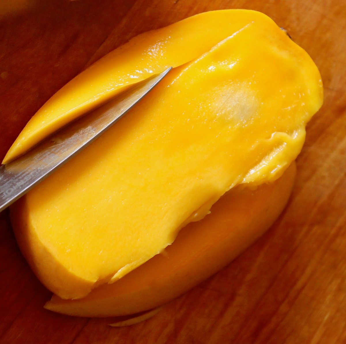 Flesh being cut off from around a mango pit.