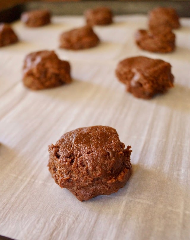 raw chocolate avocado cookies on parchment-lined baking sheet