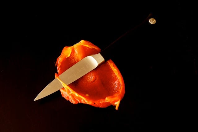 inside of a piece of roasted red pepper with paring knife
