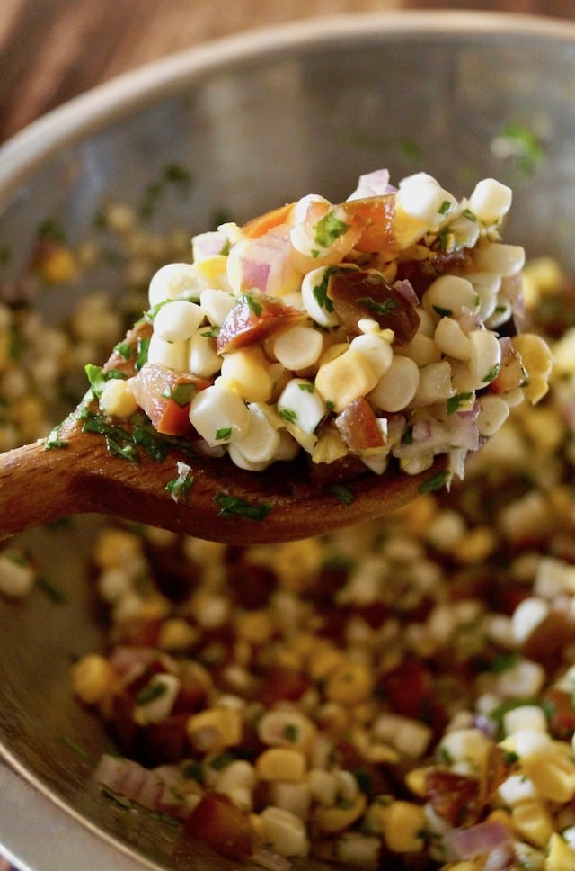 Spoonful of Corn Salsa held above bowl