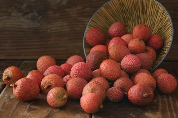 pile of lychees spilling out of a bowl