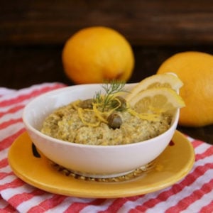 Lemon Caper Pesto in a white bowl on yellow plate
