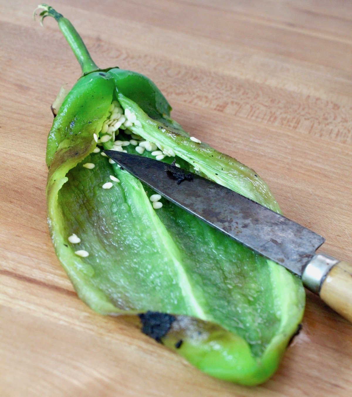 roasted and cut hatch chile with seeds being removed with knife