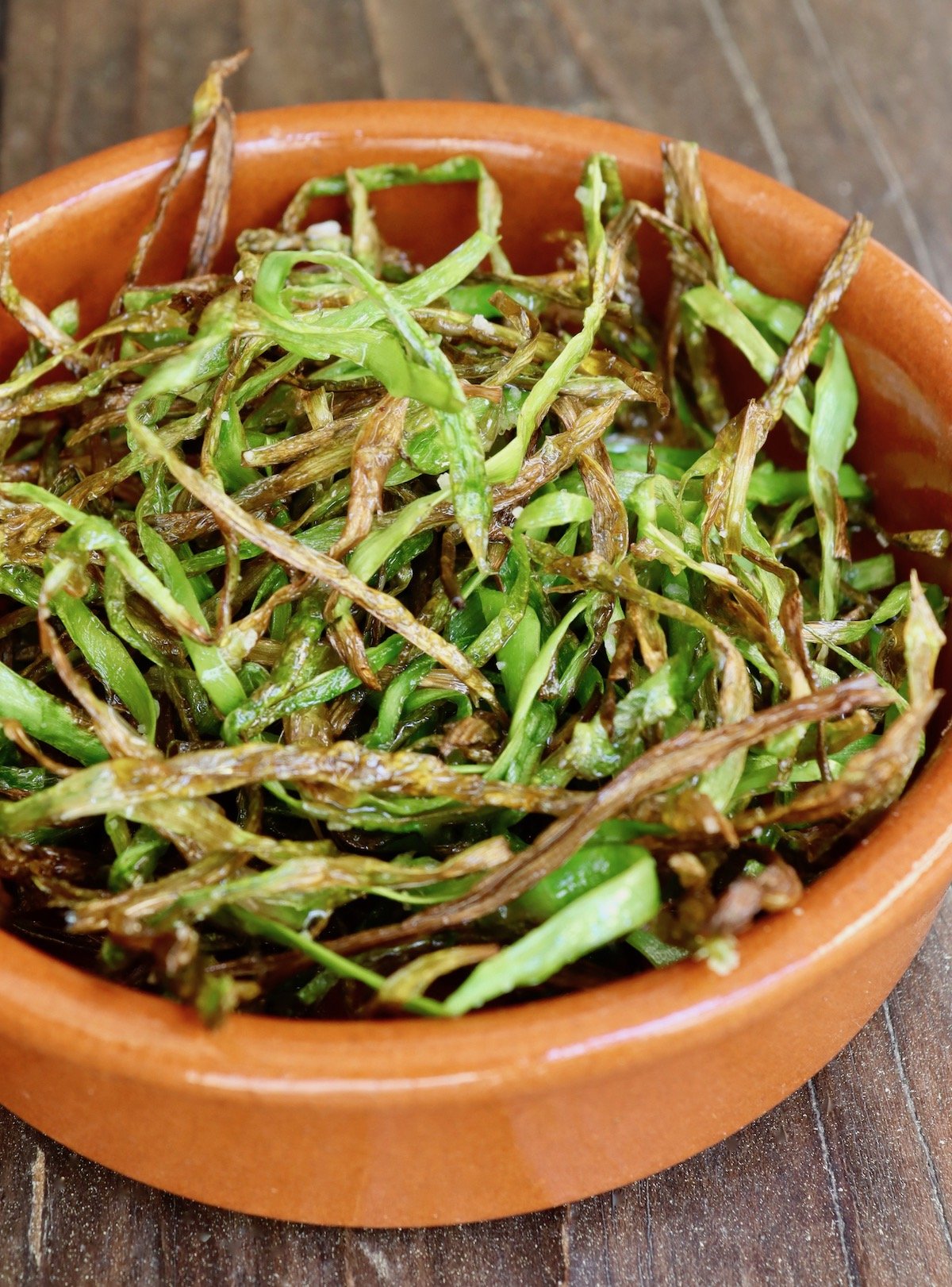 Crispy asparagus spears in a terra cotta bowl
