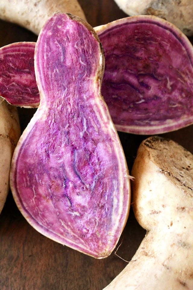 one raw okinawan purple potato slied in half