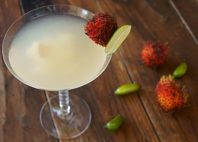 Rambutan Martini, a Rambutini, in a martini glass with fresh rambutan and finger limes.