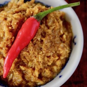 curry paste in small white bowl with red pepper