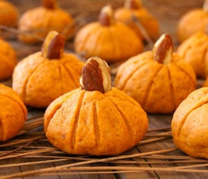 Pumpkin Almond Cookies for Halloween and Thanksgiving lined up, and sitting on pine needles.