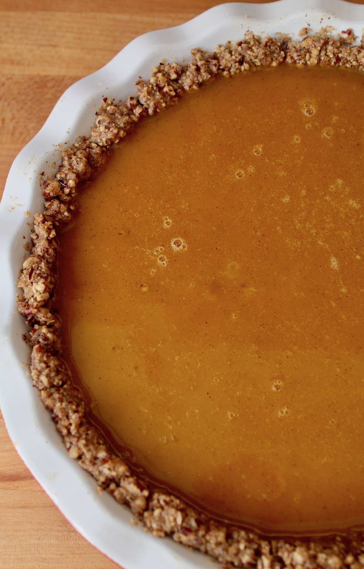 unbaked pumpkin pie in white pie plate