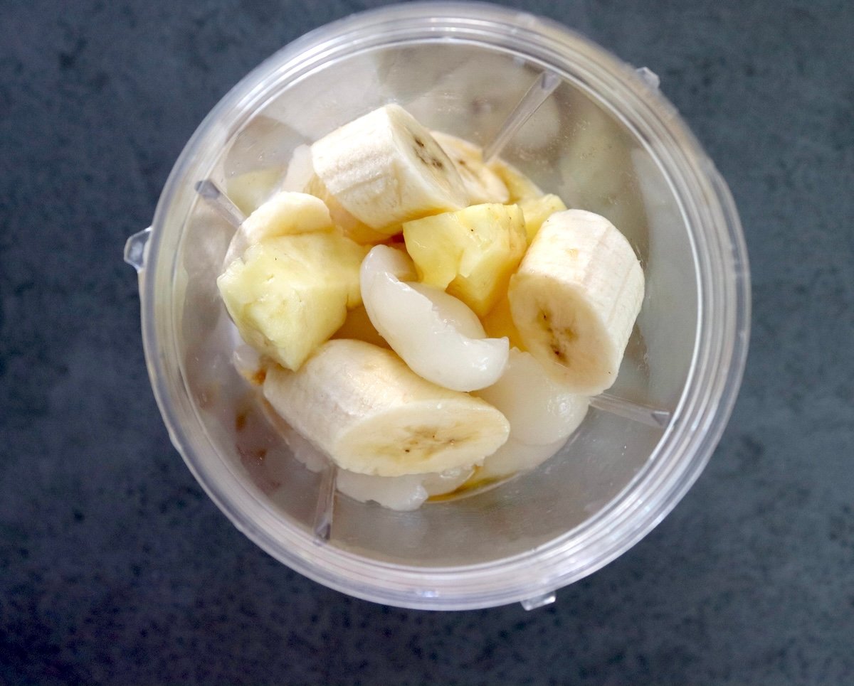 Cut banana, pineapple and rambutan in bottom of blender.